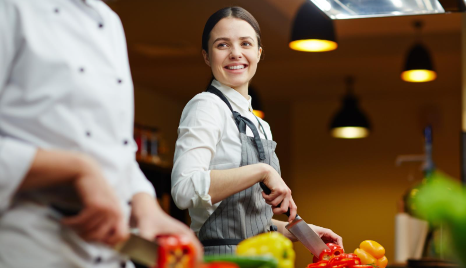 A chef using a knife to chop vegetables.