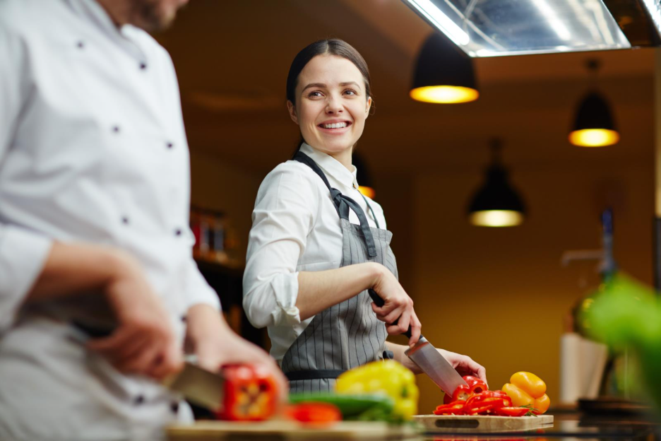 A chef using a knife to chop vegetables.