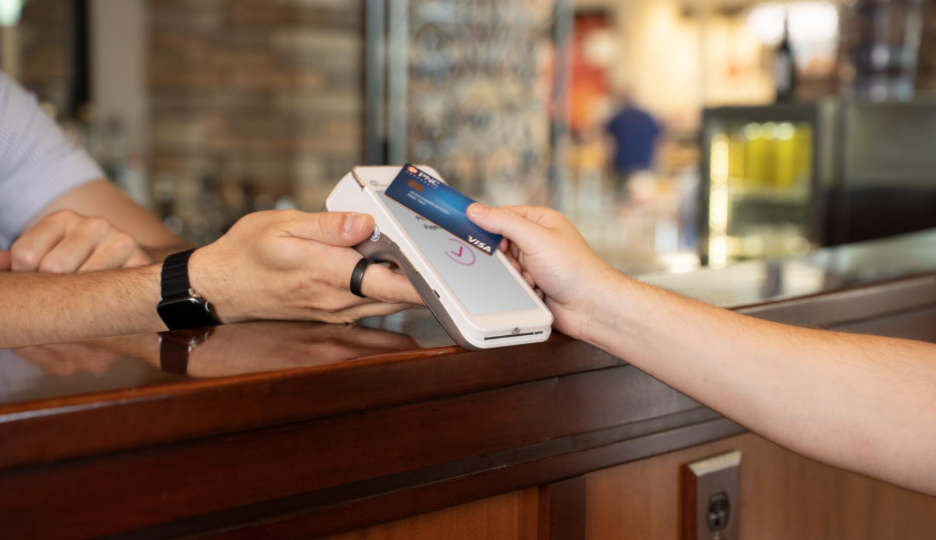 A customer uses their credit card to pay at a restaurant
