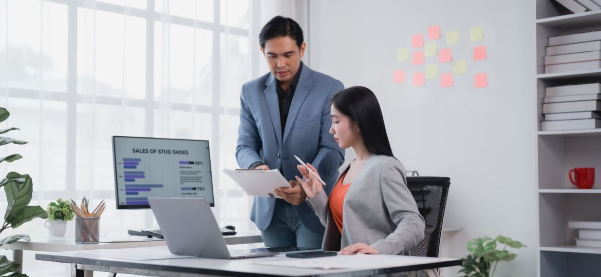Two businesspeople reviewing a report in their office.