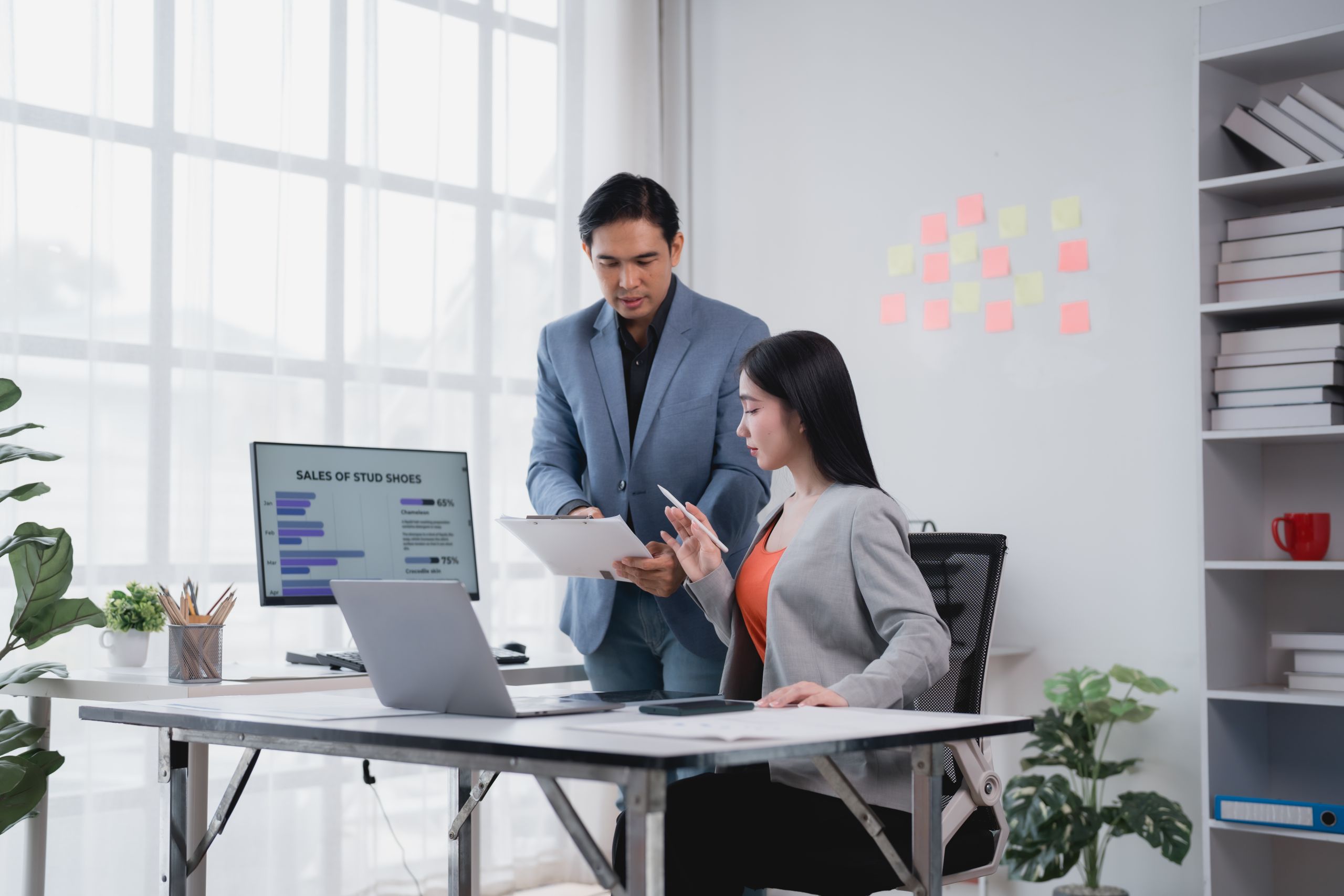Two businesspeople reviewing a report in their office.